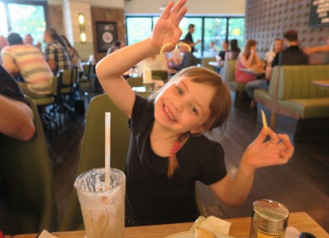 little girl happy in local restaurant with chips maidstone