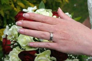 woman's hand with wedding ring over flowers