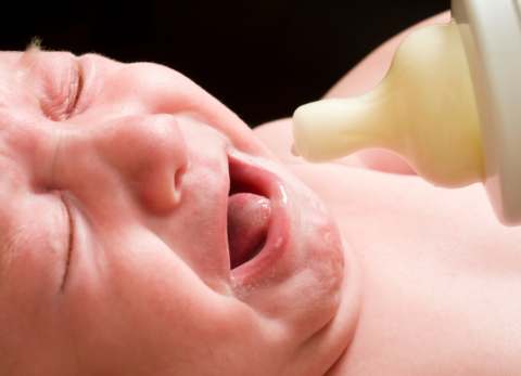 baby crying with bottle