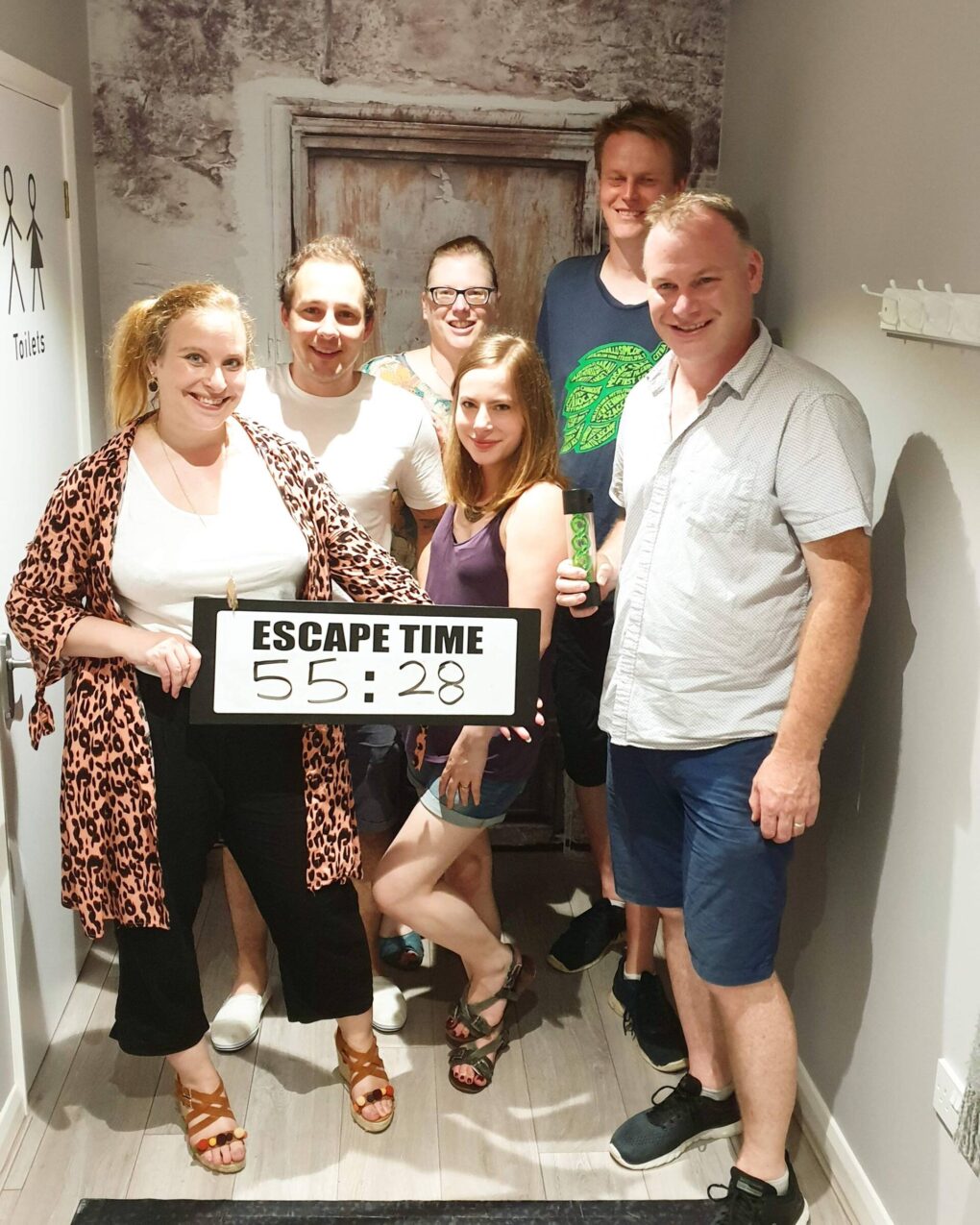group of people holding a sign with their escape time