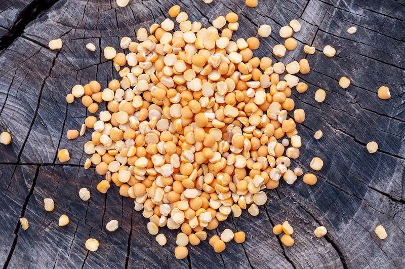 Dry split peas scattered on an old stump. Grocery.