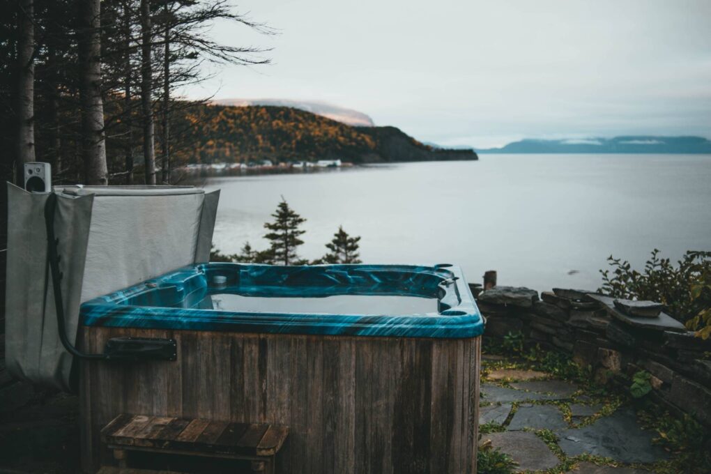 hot tub outside with a lakeside mountain view